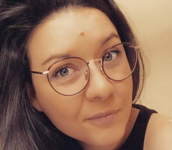 portrait photo de Laetitia Guilbert, elle porte des lunettes et elle fait une sourire